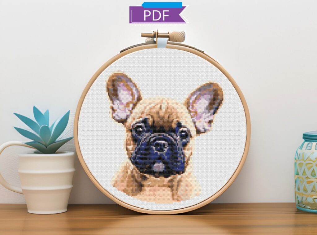 French bulldog cross stitch in a wooden hoop resting on a shelf