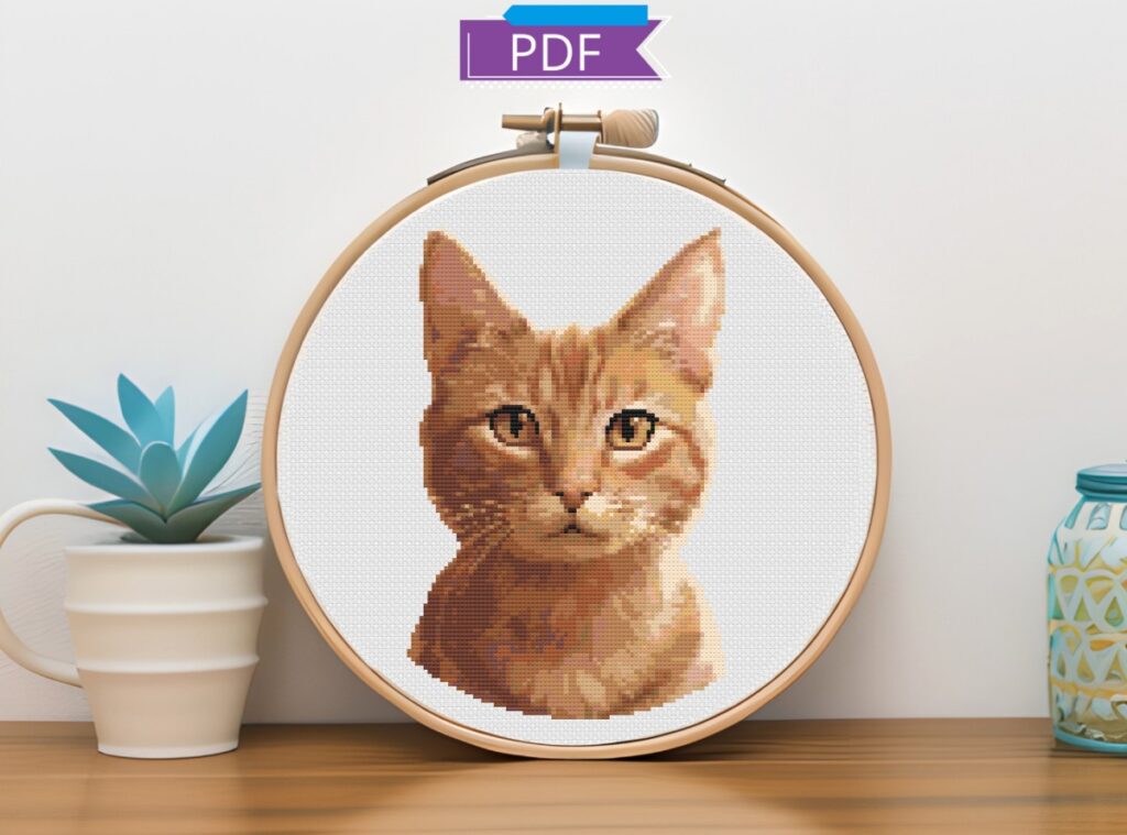 Butterscotch tabby cat cross stitch in an embroidery hoop